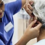 An elderly woman with hearing aid