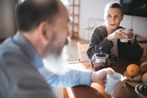 couple-coffee-hearing loss Couple having coffee at breakfast table.
