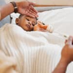 Mother feeling the forehead of her sick child