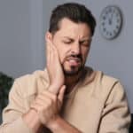 Man with tinnitus holding his ear