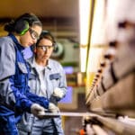Factory workers wearing hearing protection and eyeware