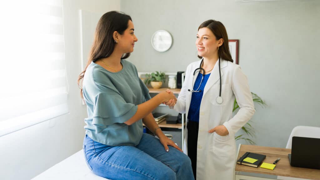 Doctor shaking hands with her patient.