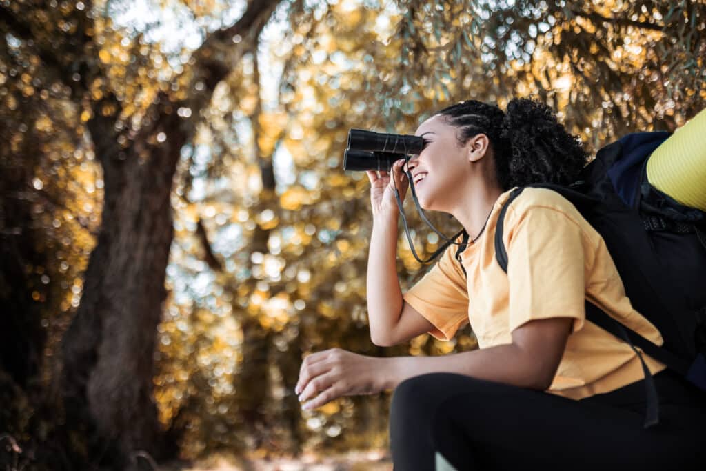 Hiker watching the birds through binoculars.