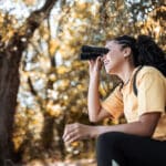Hiker watching the birds through binoculars.